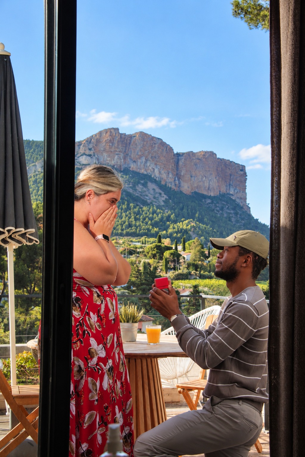 Merveilles et Megan lors de leur demande en mariage, sur une terrasse face aux montagnes
